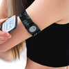 Person wearing a Freestyle Libre 3 armband on their upper arm, holding the glucose monitor to check levels. The black armband with blue patterns provides a snug fit for sports and activities.